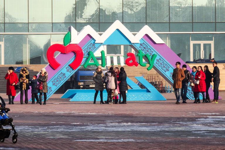 Students pose in front of the Almaty sign