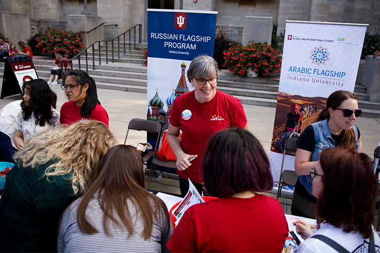 Faculty and staff for the IU Flagship Programs stand at tables passing out information at a First Thursday event