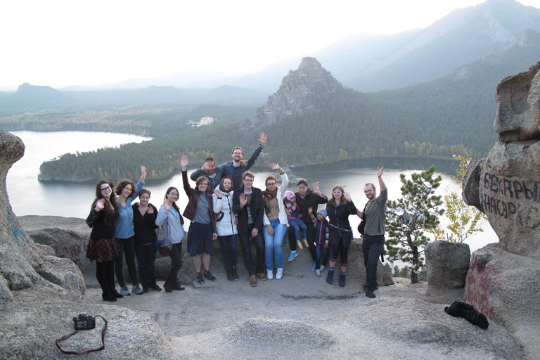 capstone students posing in front of mountains and lake
