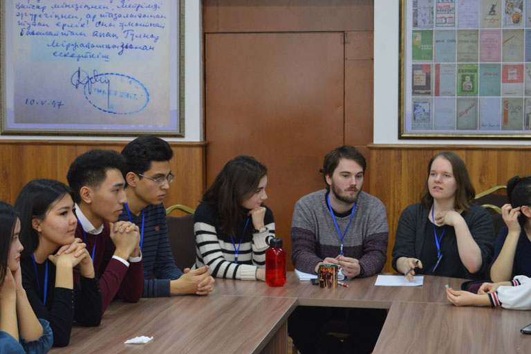 Students sitting around a table in a discussion group