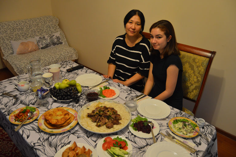 A student eating a meal with a host family