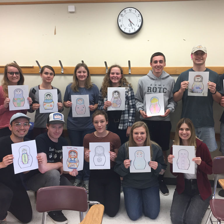 students pose with their drawings