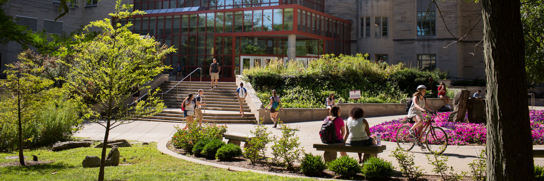 Students sitting outside of a campus building on a beautiful day